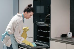 Housewife in yellow gloves cleaning the kitchen